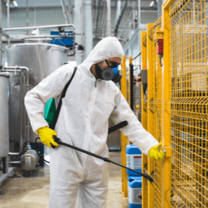 which is the best pest control company - How Pests Can Ruin Your Manufacturing Business - a pest control technician spraying pesticide in a factory