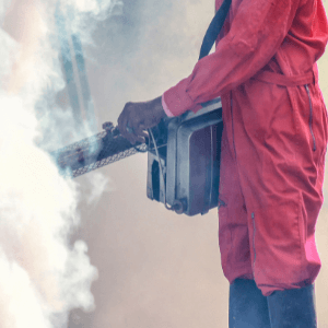fumigation services St Catharines - Keep Out Pests With Fumigation Services - a technician in red coveralls using his fumigation equipment